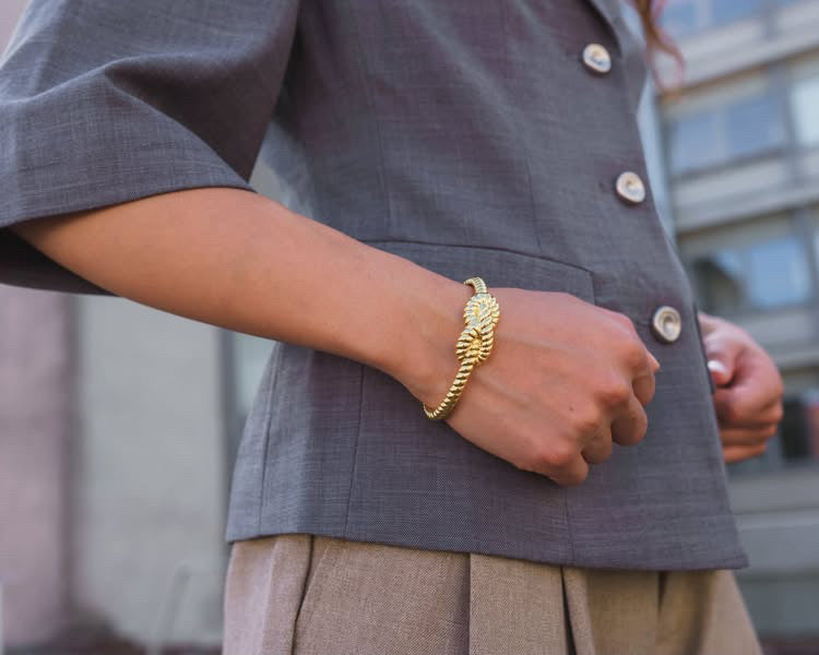 Knot Cuff Gold båret på håndleddet med grå skjorte